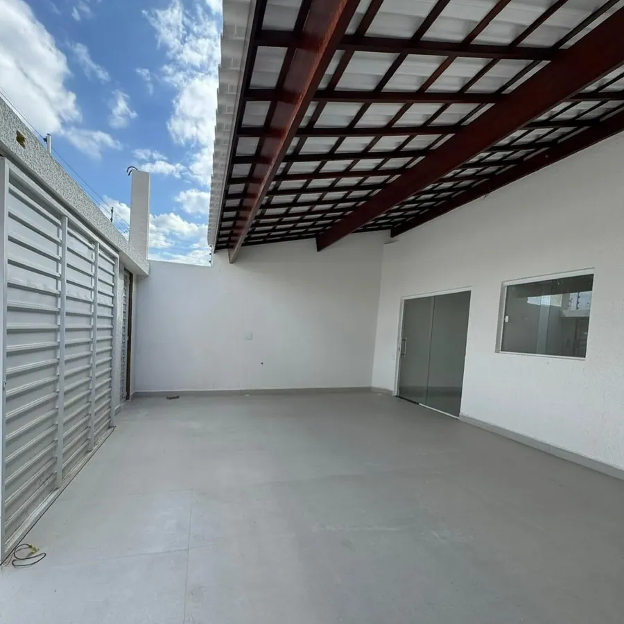 Garagem ampla coberta com pergolado de madeira e piso em porcelanato
