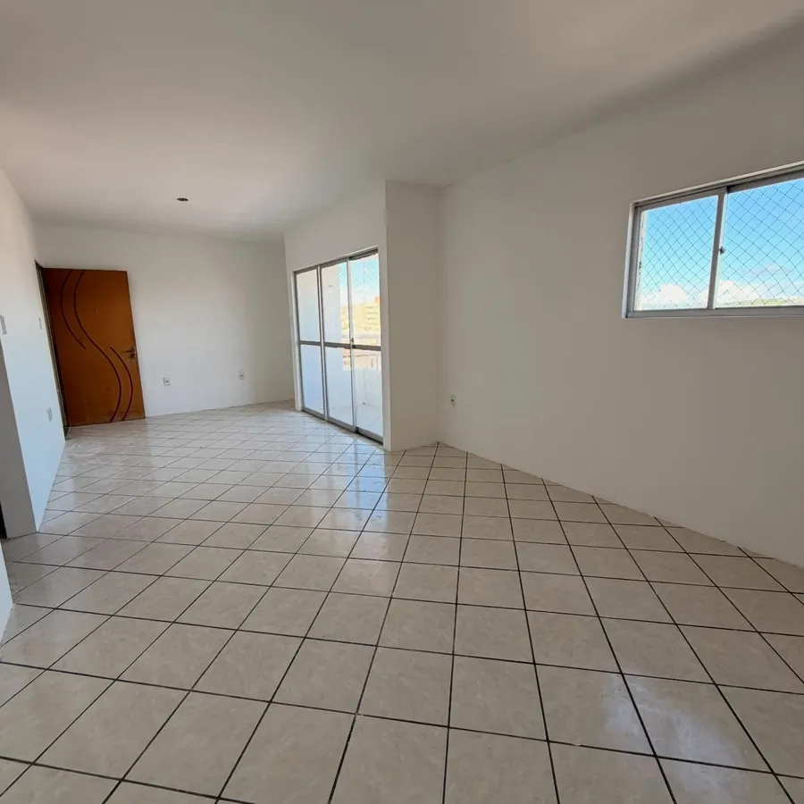 Sala ampla e iluminada com acesso à varanda e janela com tela de proteção